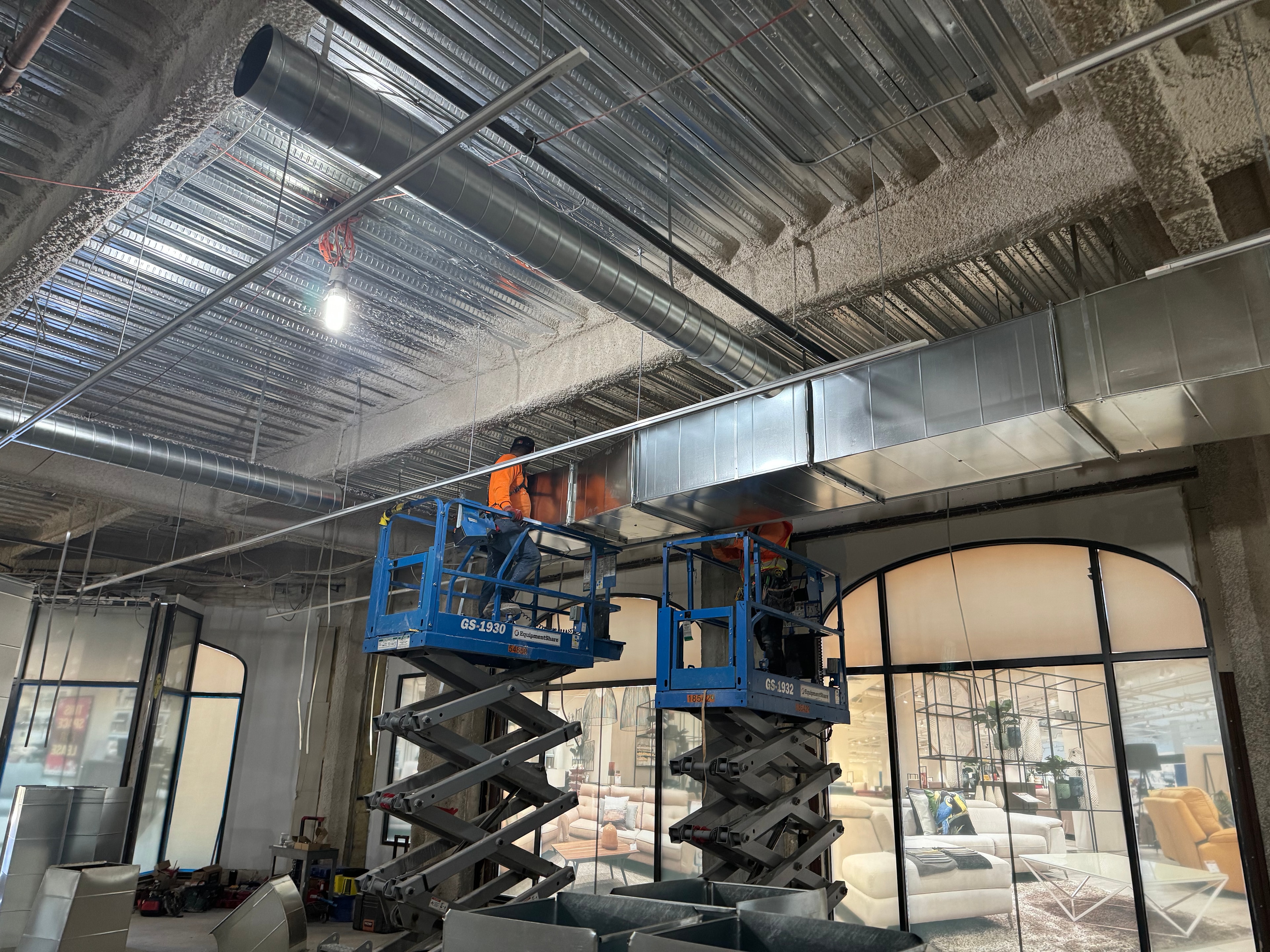 Crew installing rectangular trunk on scissor lifts