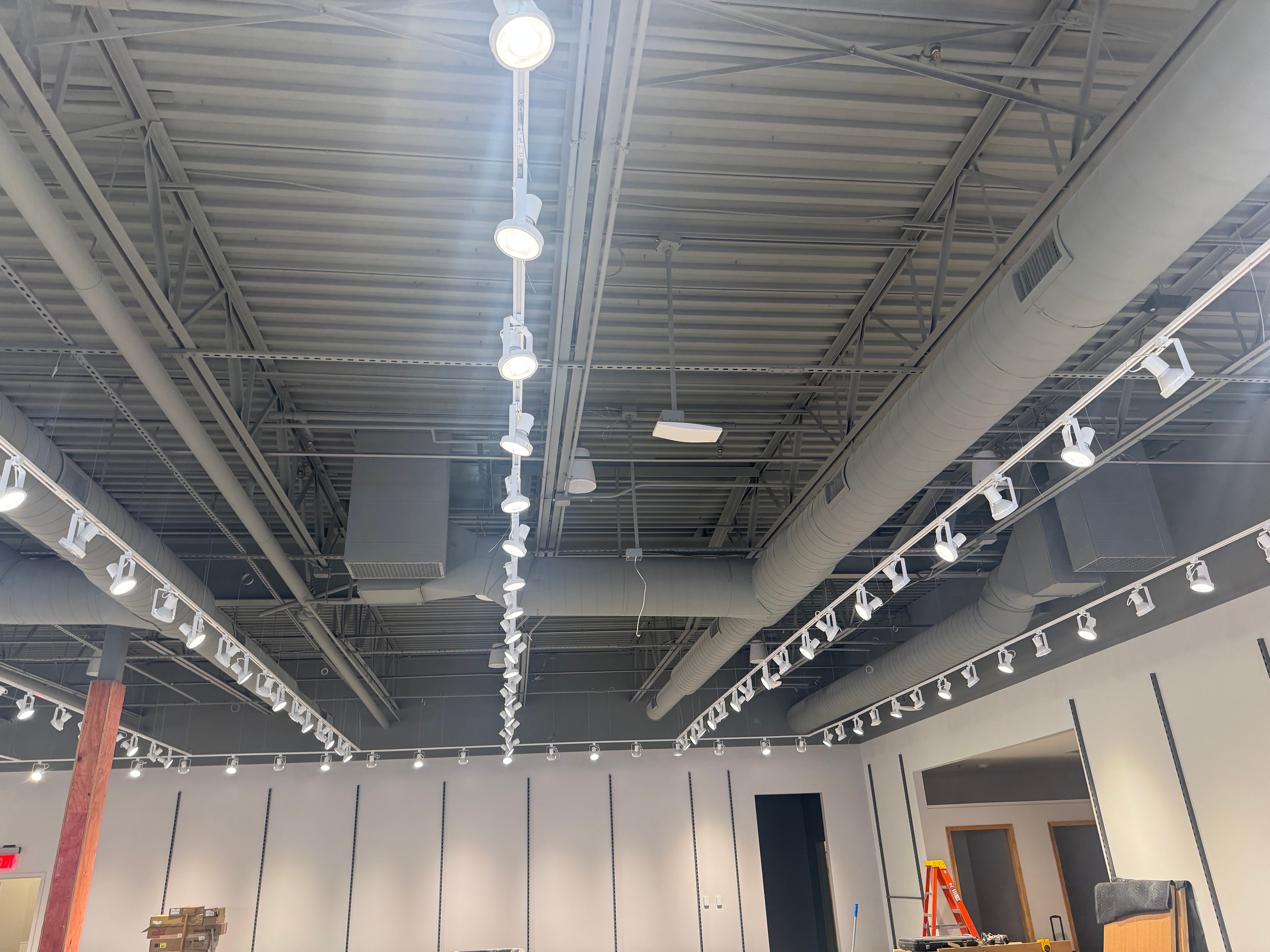 Finished retail interior — painted spiral mains with track lighting